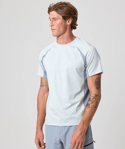 Man in light blue shirt with arm tattoos