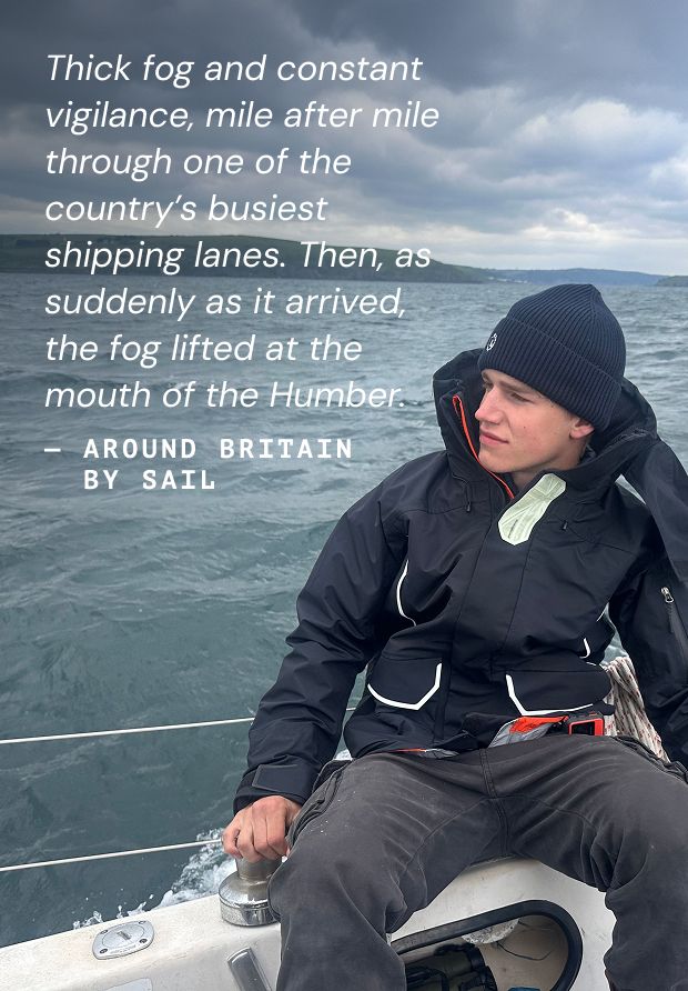 Person on sailboat in foggy waters.