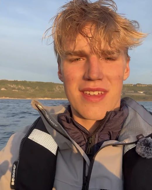 Person in life jacket by the sea.