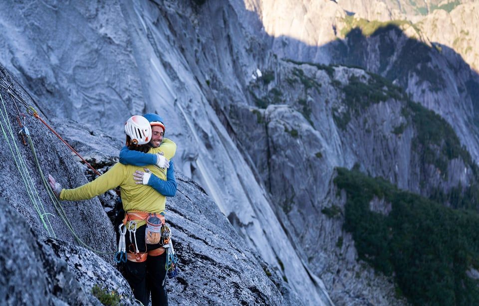 Two people hug on a climbing route. Two people hug on a climbing route.