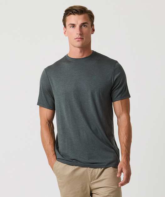 Man in gray t-shirt and beige pants posing.