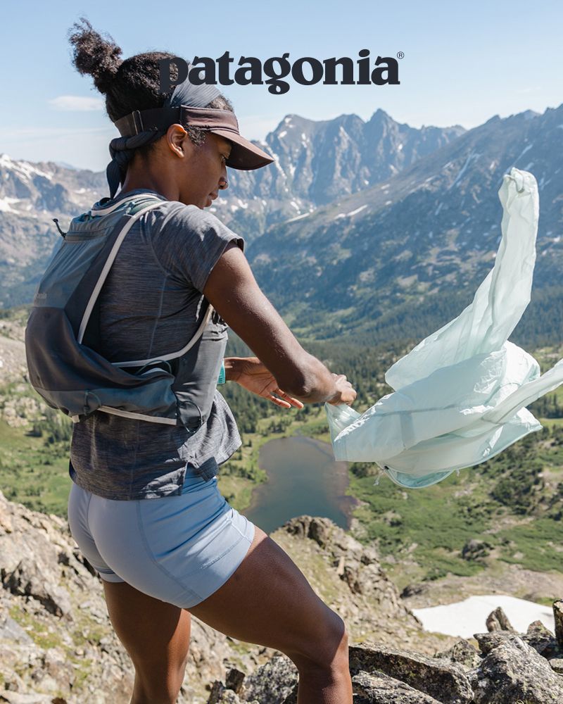 Patagonia® | Ambassador Peyton Thomas stands in the mountains with a jacket blowing in the wind.