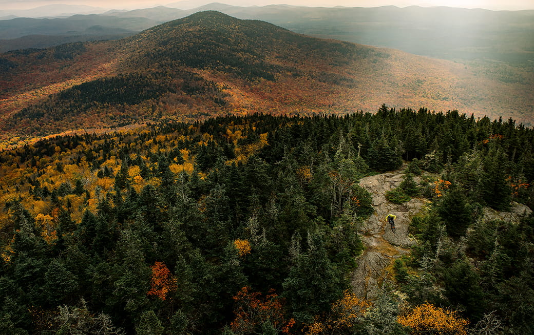 Aerial view of a cyclist riding along a rocky mountain trail