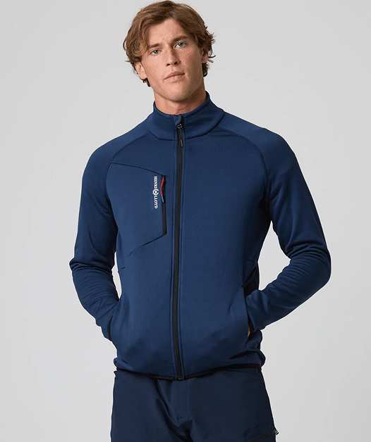 Man in blue zip-up jacket with hands in pockets.