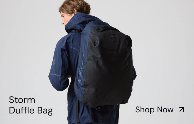 Person with black duffle bag, side view.